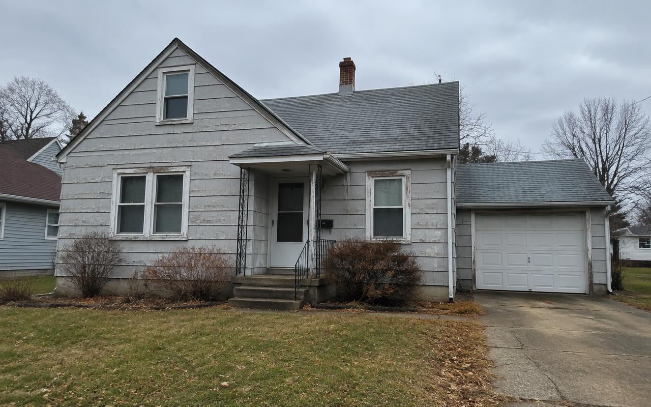 House with faded old siding after new fiber cement siding installation — before
