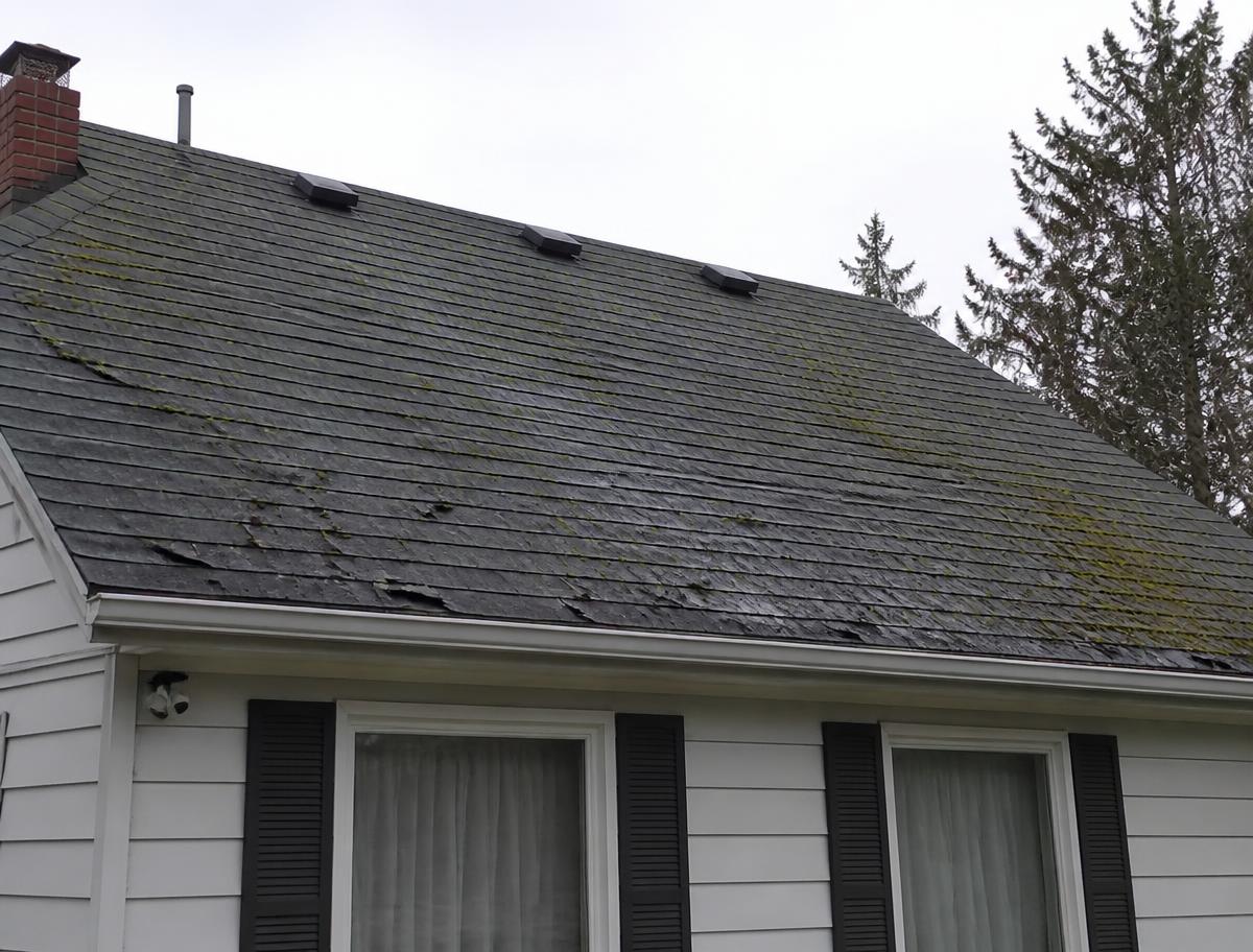 Storm-damaged roof replaced with new architectural shingles — before